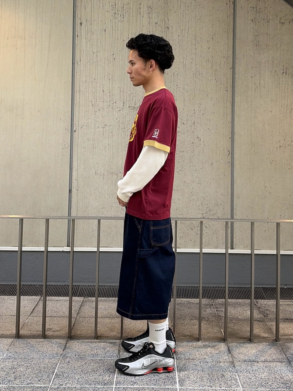 レッド系のTシャツ/カットソー、ブルー系のデニムパンツ、ホワイト系のTシャツ/カットソーを着用したメンズの春コーディネートの2枚目の写真