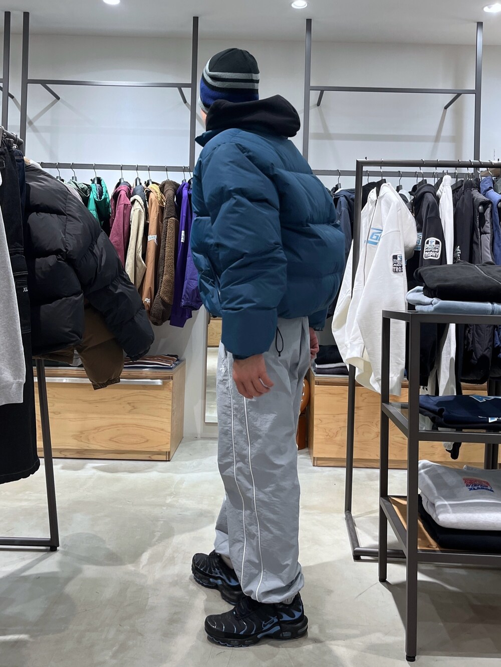 ブルー系のダウンジャケット/コート、グレー系のその他パンツ、ブラック系のニットキャップ/ビーニーを着用したメンズの秋コーディネートの3枚目の写真