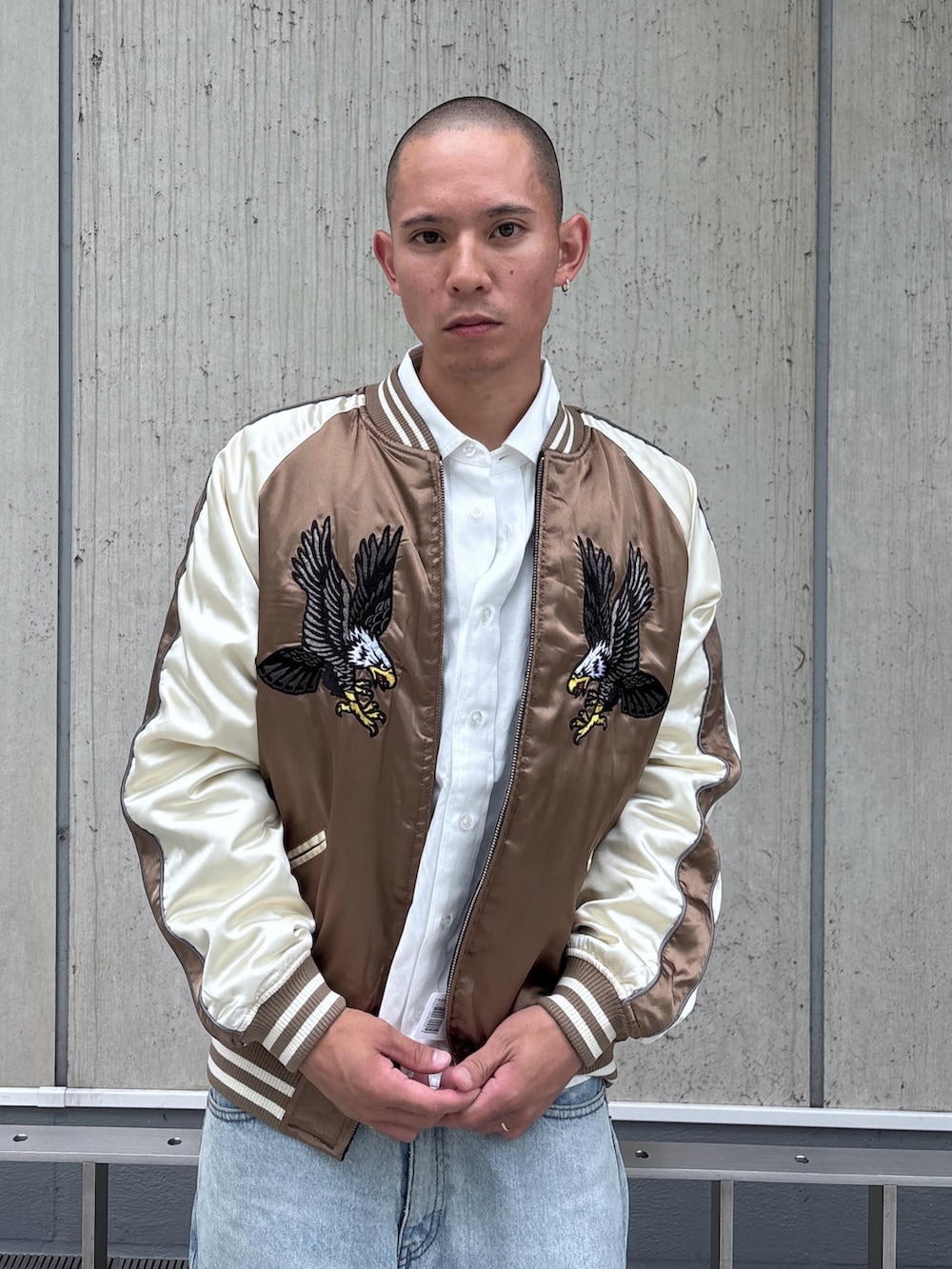 ブラウン系のスカジャン、ホワイト系のシャツ/ブラウス、ブラック系のデニムパンツを着用したメンズの秋コーディネートの6枚目の写真