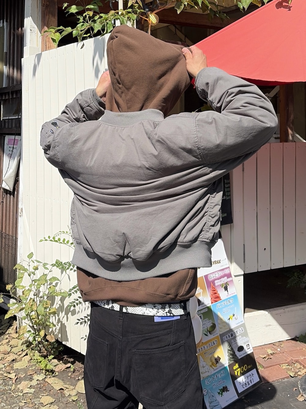 ブラウン系のパーカー、その他のブルゾン、ブラック系のその他パンツを着用したメンズの秋コーディネートの6枚目の写真