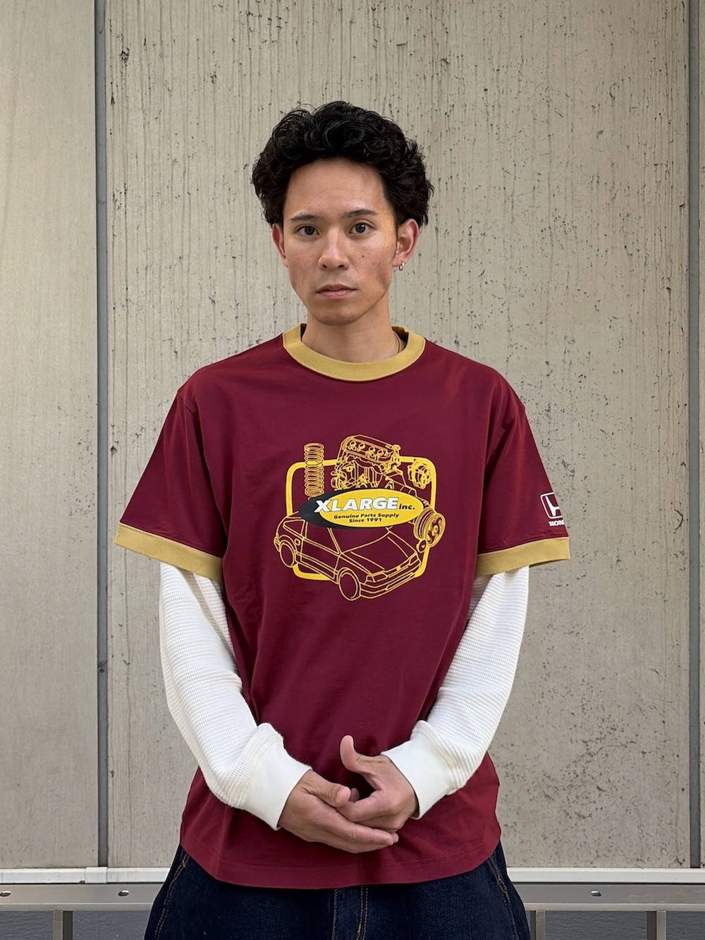 レッド系のTシャツ/カットソー、ブルー系のデニムパンツ、ホワイト系のTシャツ/カットソーを着用したメンズの春コーディネートの5枚目の写真