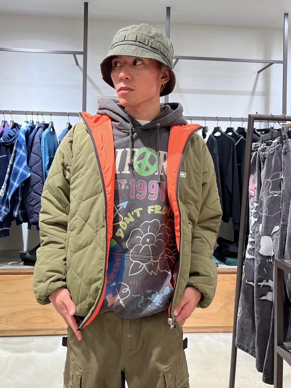 グリーン系のブルゾン、ブラック系のパーカー、グリーン系のその他パンツを着用したメンズの秋コーディネートの4枚目の写真