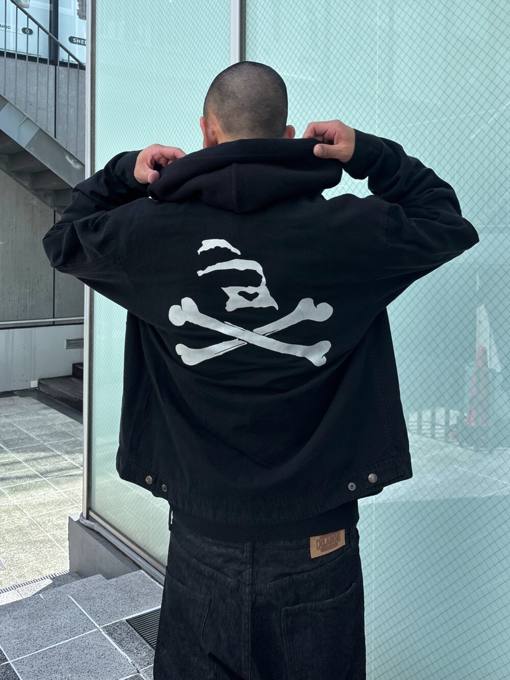 ブラック系のニット/セーター、ブラック系のデニムパンツ、ブラック系のその他アウターを着用したメンズの秋コーディネートの8枚目の写真