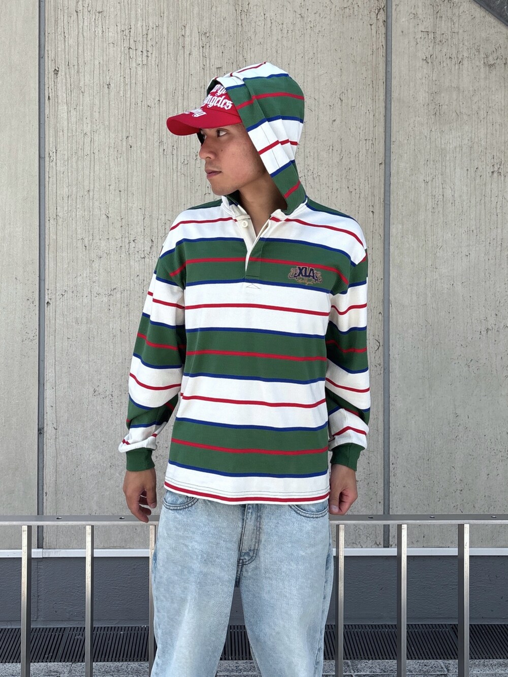 ホワイト系のTシャツ/カットソー、ブラック系のデニムパンツ、レッド系のキャップを着用したメンズの秋コーディネートの7枚目の写真