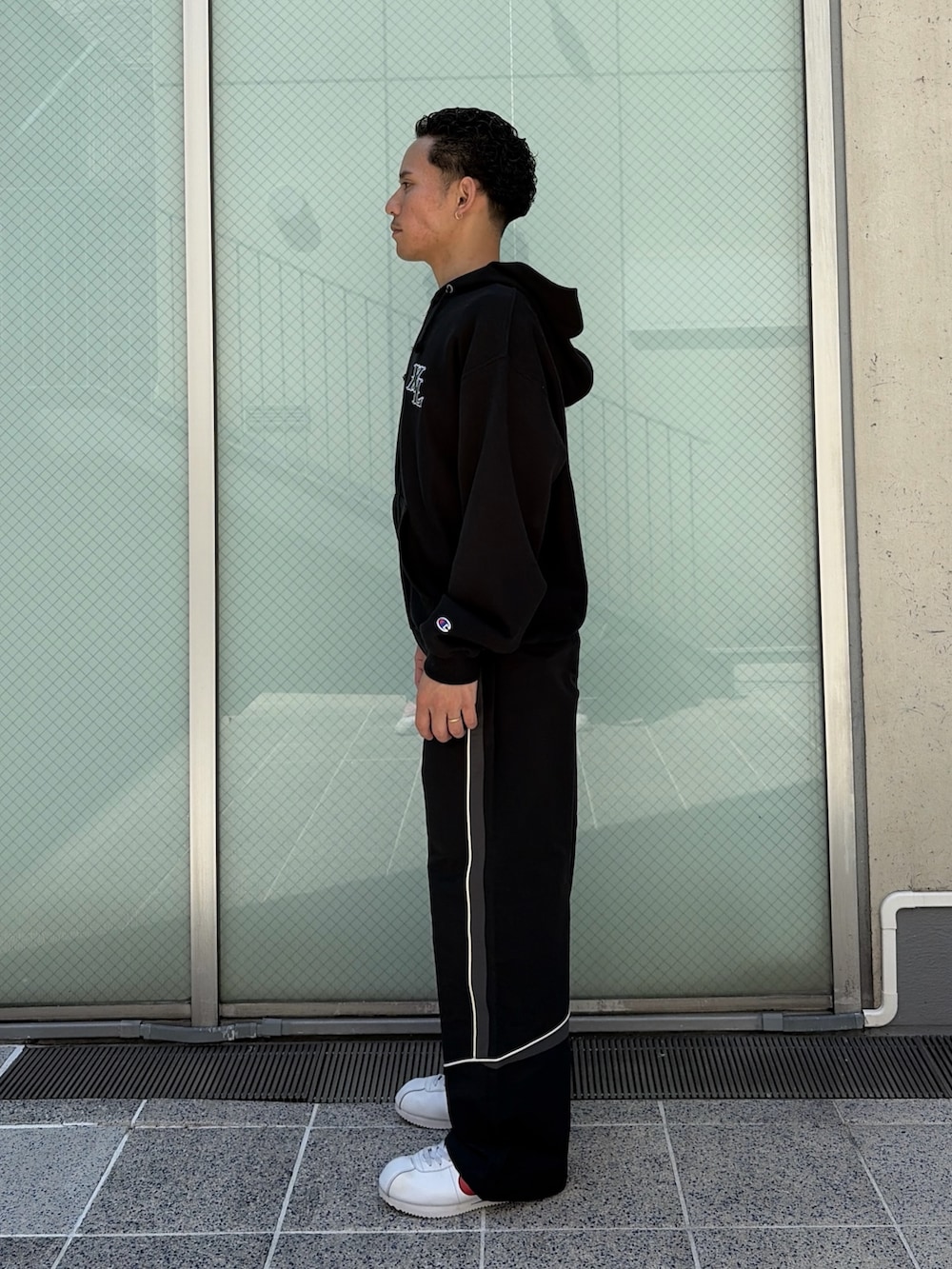 ブラウン系のパーカー、ブラック系のその他パンツを着用したメンズの春コーディネートの2枚目の写真