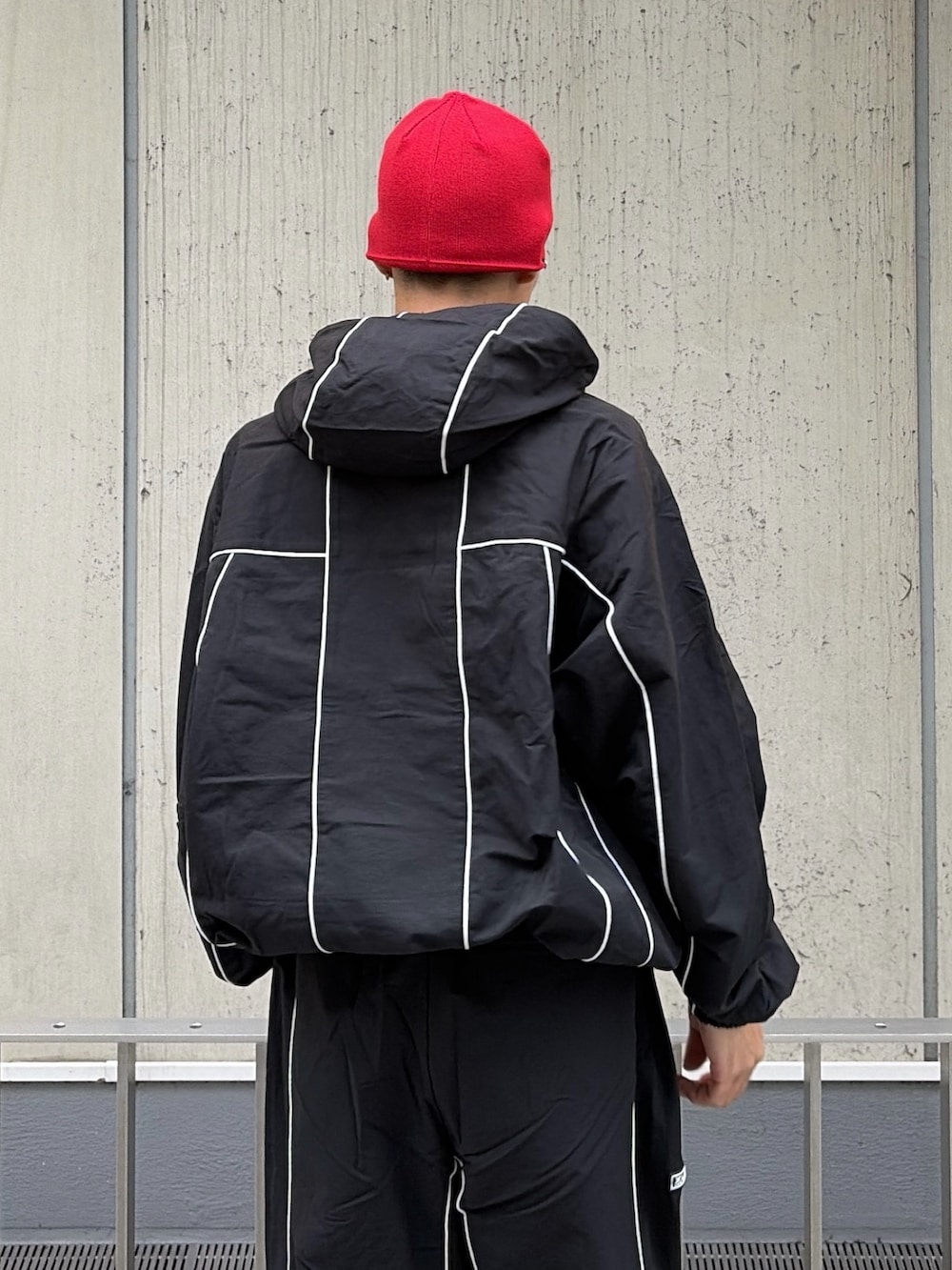 ブラック系のブルゾン、ブラック系のその他パンツ、レッド系のニットキャップ/ビーニーを着用したメンズの秋コーディネートの10枚目の写真