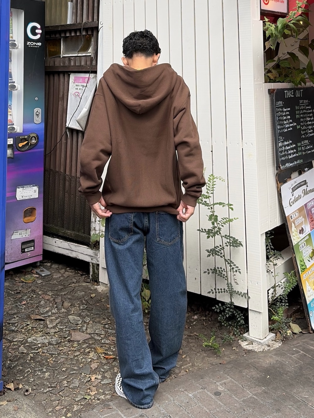 グレー系のパーカー、ブルー系のデニムパンツを着用したメンズの秋コーディネートの5枚目の写真