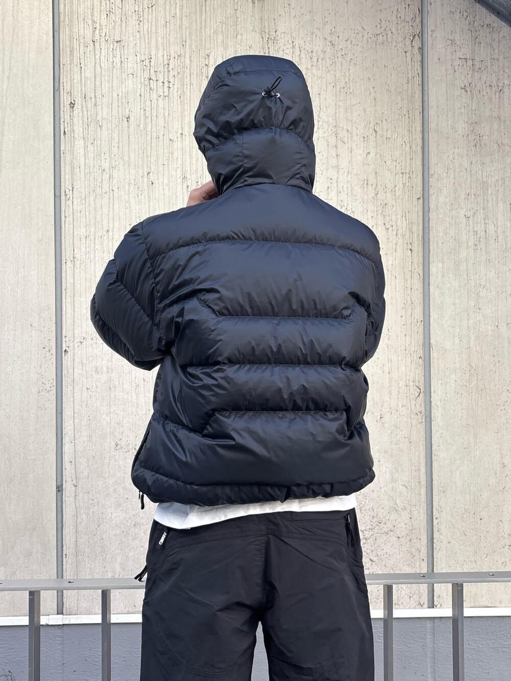 グリーン系のダウンジャケット/コート、ブラック系のその他パンツを着用したメンズの冬コーディネートの7枚目の写真