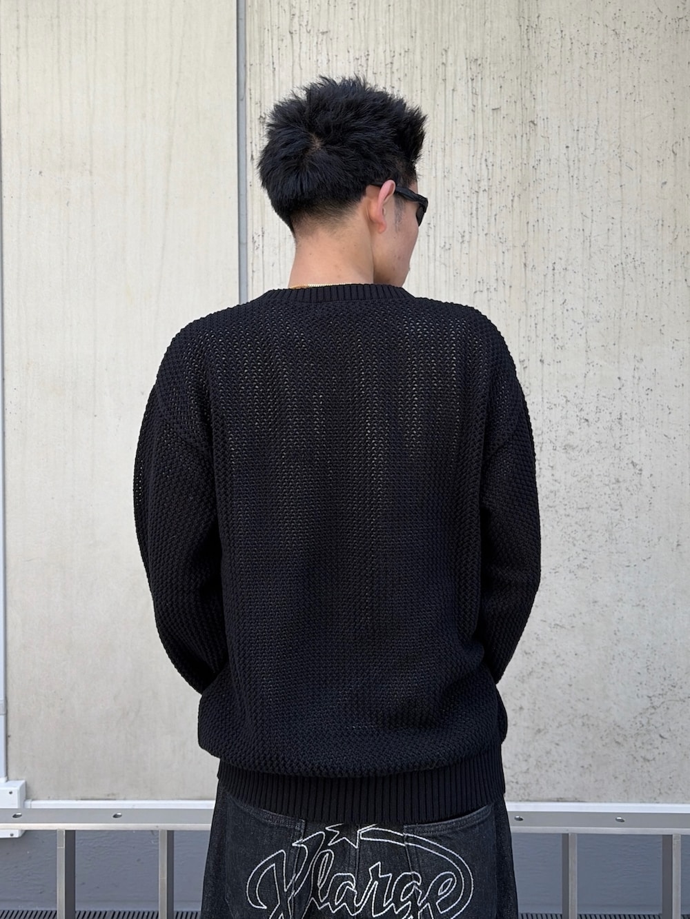 ブラック系のニット/セーター、ブラック系のデニムパンツを着用したメンズの春コーディネートの6枚目の写真