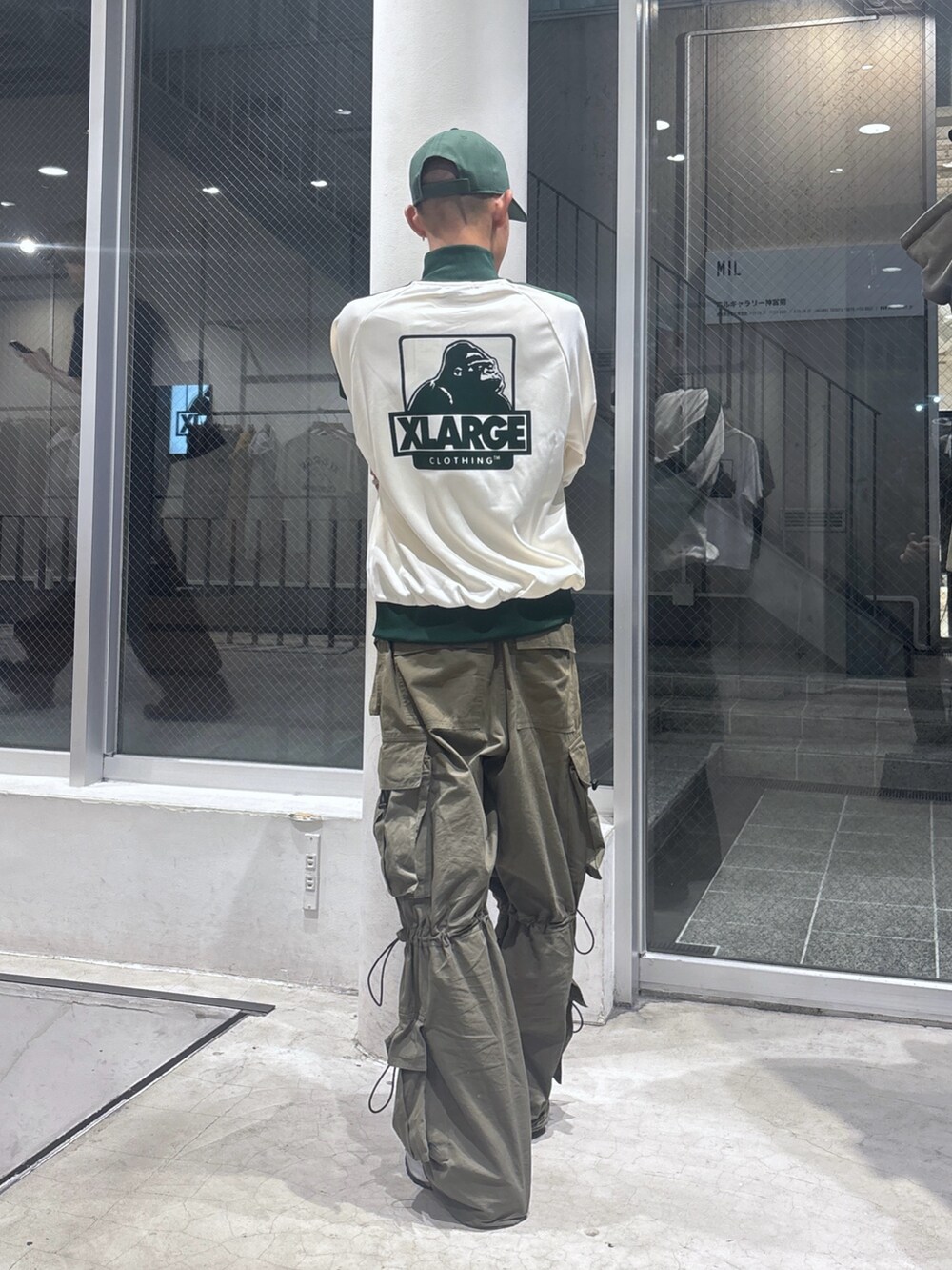 ホワイト系のブルゾン、グリーン系のカーゴパンツ、グリーン系のキャップを着用したメンズの秋コーディネートの4枚目の写真