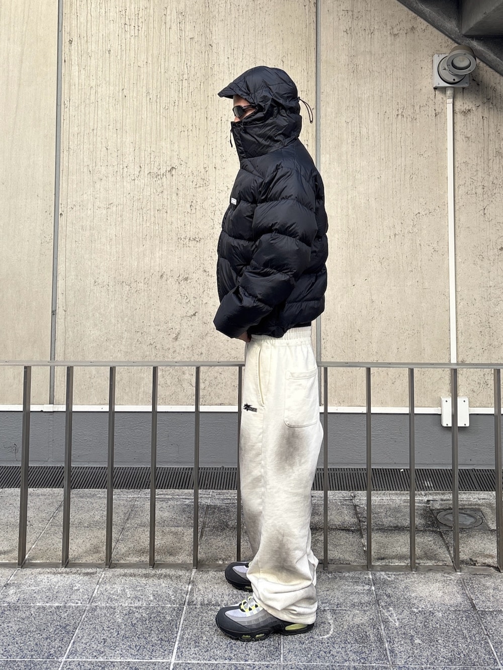 ブラウン系のダウンジャケット/コート、ホワイト系のスウェットパンツを着用したメンズの秋コーディネートの2枚目の写真