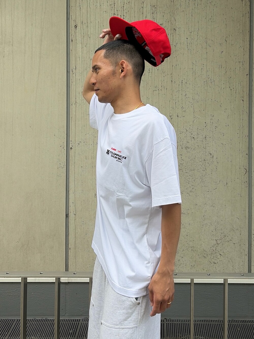 グレー系のスウェットパンツ、レッド系のキャップを着用したメンズの夏コーディネートの7枚目の写真