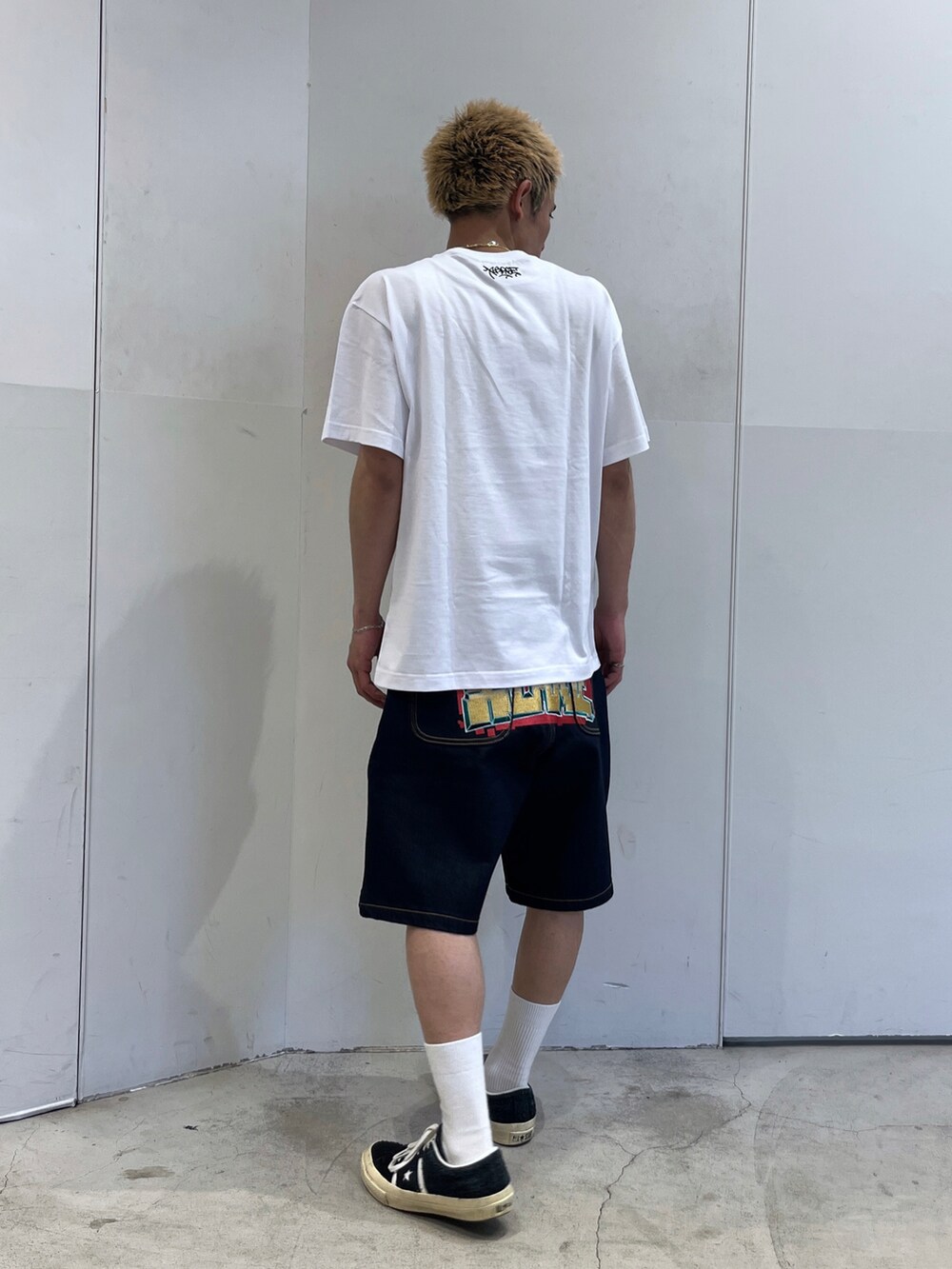 ホワイト系のTシャツ/カットソー、ブラック系のデニムパンツを着用したメンズの夏コーディネートの3枚目の写真