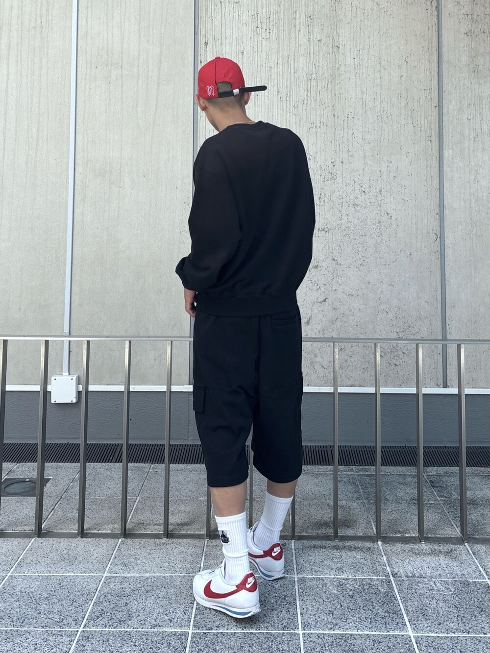 ブラック系のスウェット、ブラック系のスウェットパンツ、レッド系のキャップを着用したメンズの秋コーディネートの3枚目の写真