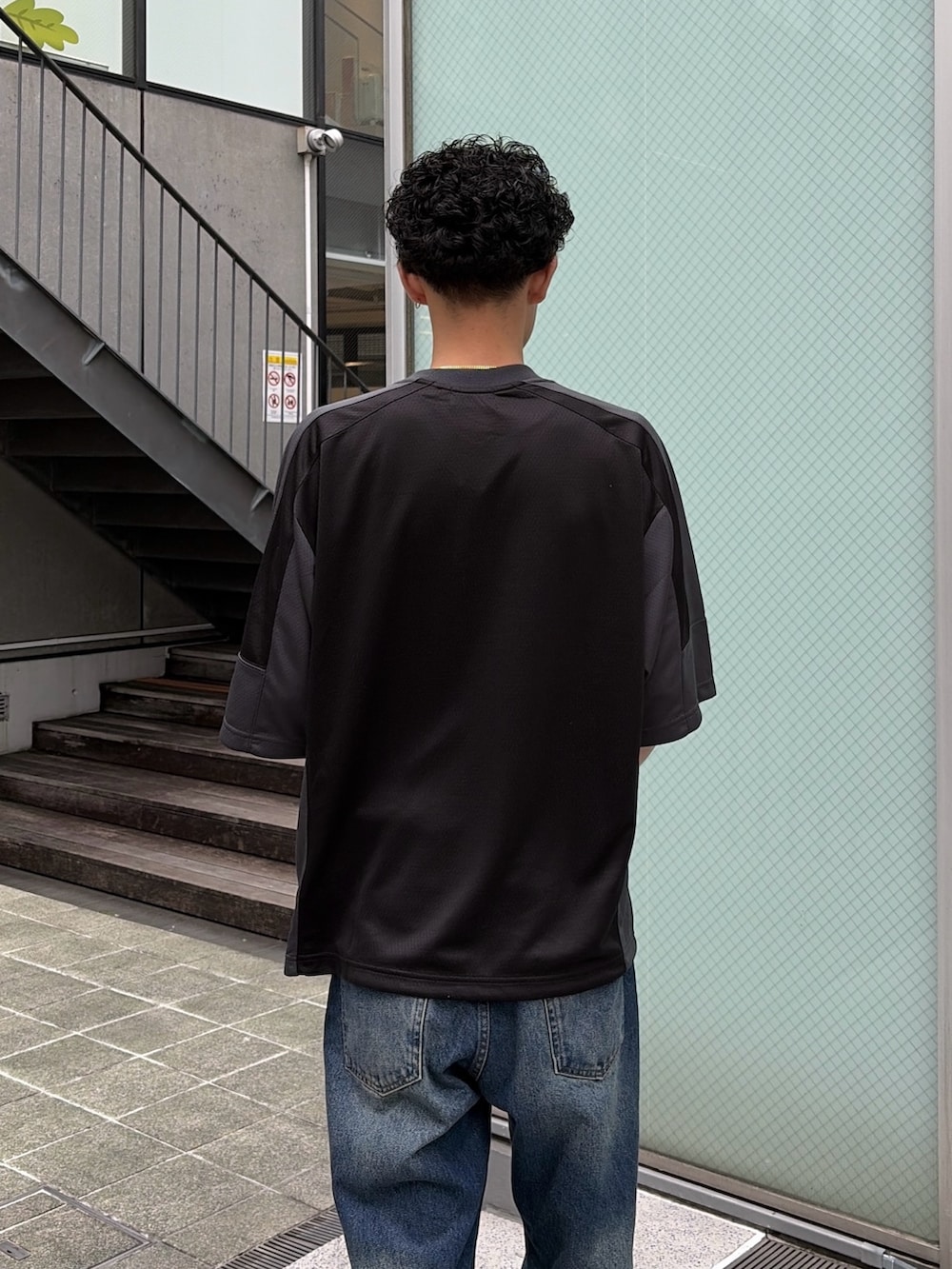 ブルー系のデニムパンツ、ブラック系のシャツ/ブラウスを着用したメンズの春コーディネートの6枚目の写真