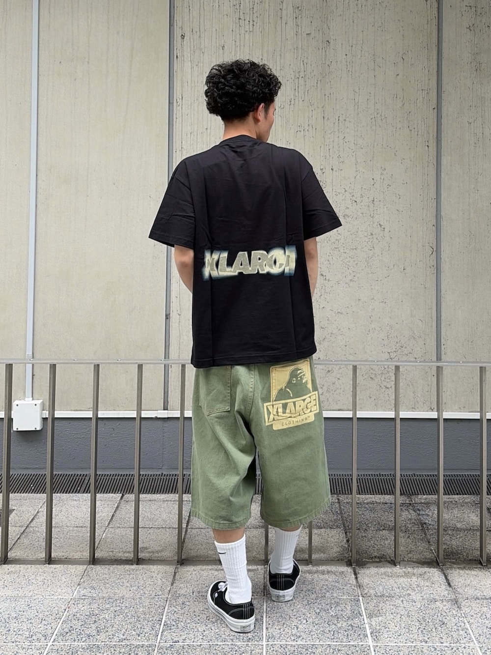 グリーン系のデニムパンツ、ブラック系のTシャツ/カットソーを着用したメンズの春コーディネートの4枚目の写真