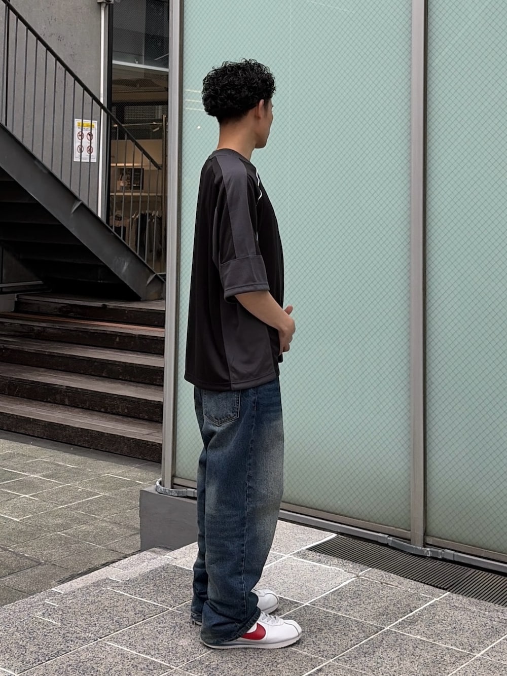 ブルー系のデニムパンツ、ブラック系のシャツ/ブラウスを着用したメンズの春コーディネートの3枚目の写真