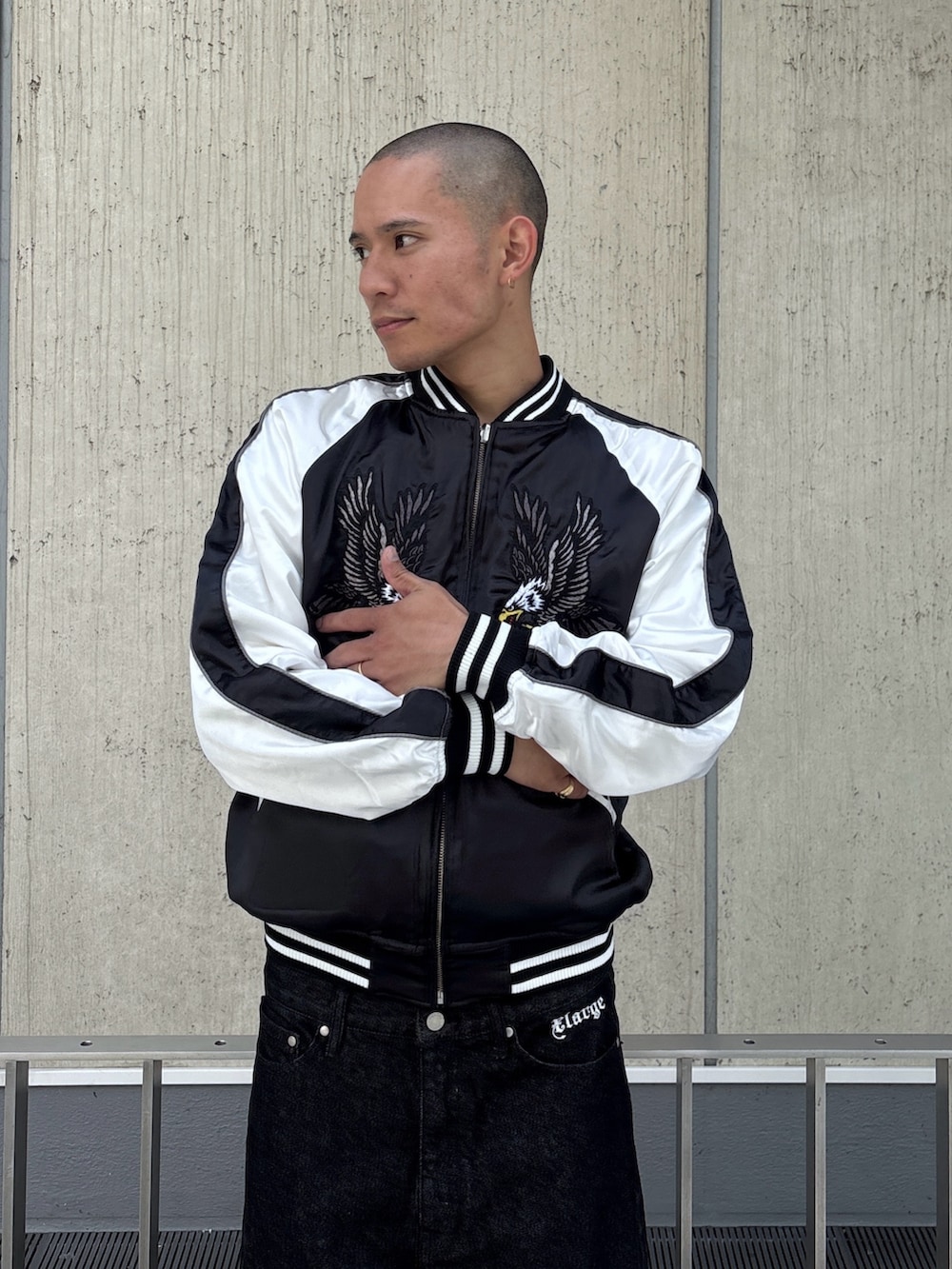 ブラック系のスカジャン、ブラック系のデニムパンツを着用したメンズの秋コーディネートの6枚目の写真