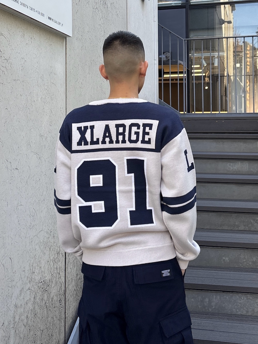 オレンジ系のニット/セーター、ブルー系のカーゴパンツを着用したメンズの冬コーディネートの6枚目の写真