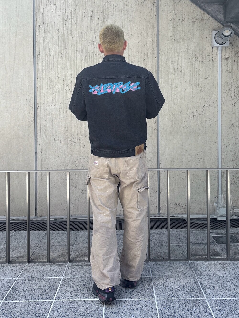 ブラック系のデニムジャケット、ベージュ系のその他パンツを着用したメンズの春コーディネートの4枚目の写真