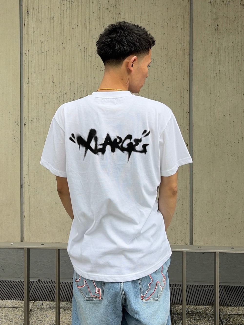 ホワイト系のTシャツ/カットソー、ブルー系のデニムパンツを着用したメンズの夏コーディネートの6枚目の写真