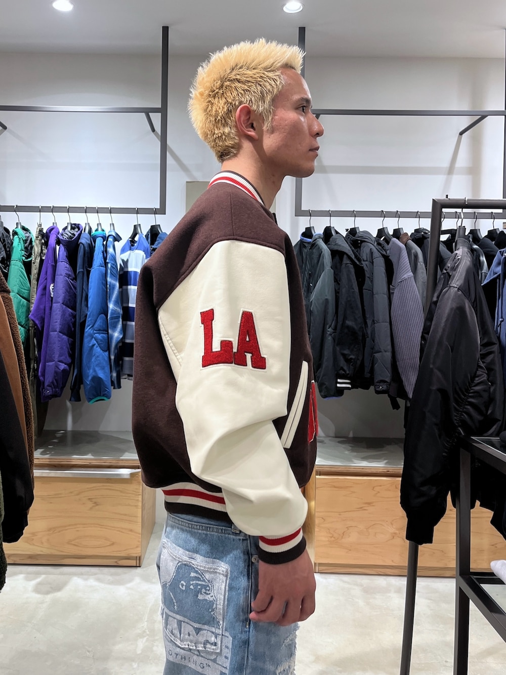 ブラウン系のスタジャン、ブルー系のデニムパンツを着用したメンズの秋コーディネートの8枚目の写真