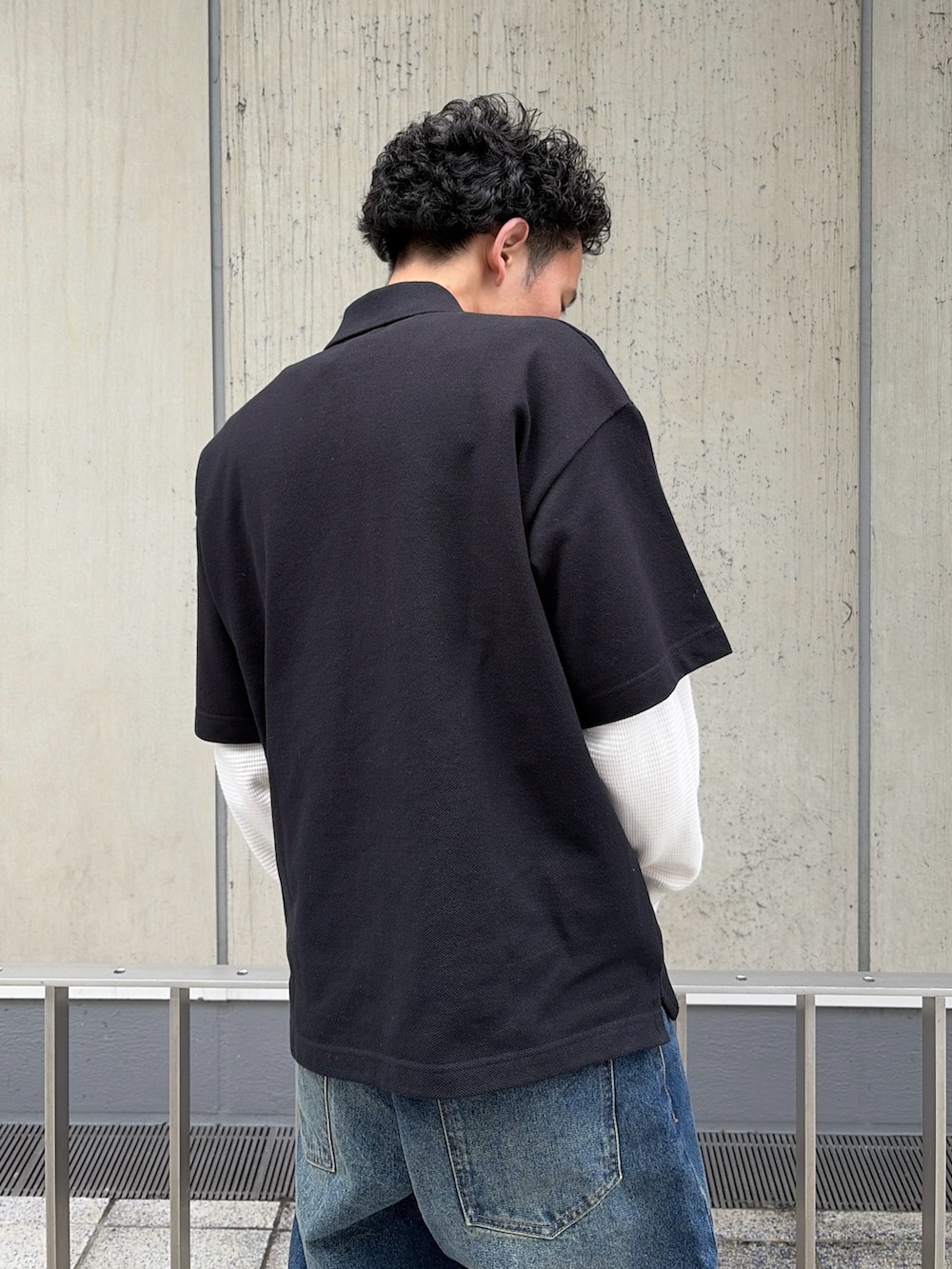 ホワイト系のTシャツ/カットソー、ブラック系のポロシャツ、ブルー系のデニムパンツを着用したメンズの春コーディネートの7枚目の写真