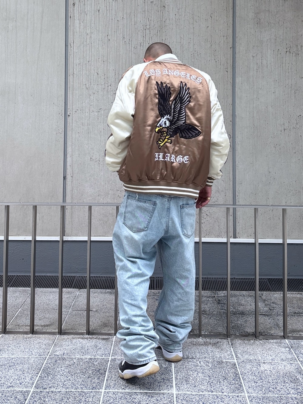 ブラウン系のスカジャン、ホワイト系のシャツ/ブラウス、ブラック系のデニムパンツを着用したメンズの秋コーディネートの5枚目の写真