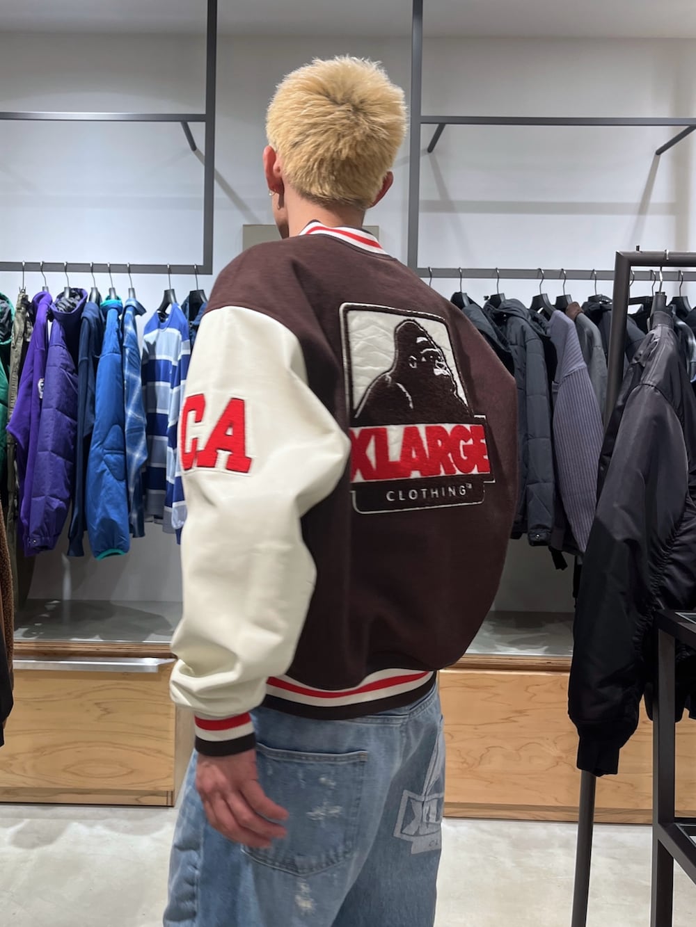 ブラウン系のスタジャン、ブルー系のデニムパンツを着用したメンズの秋コーディネートの7枚目の写真