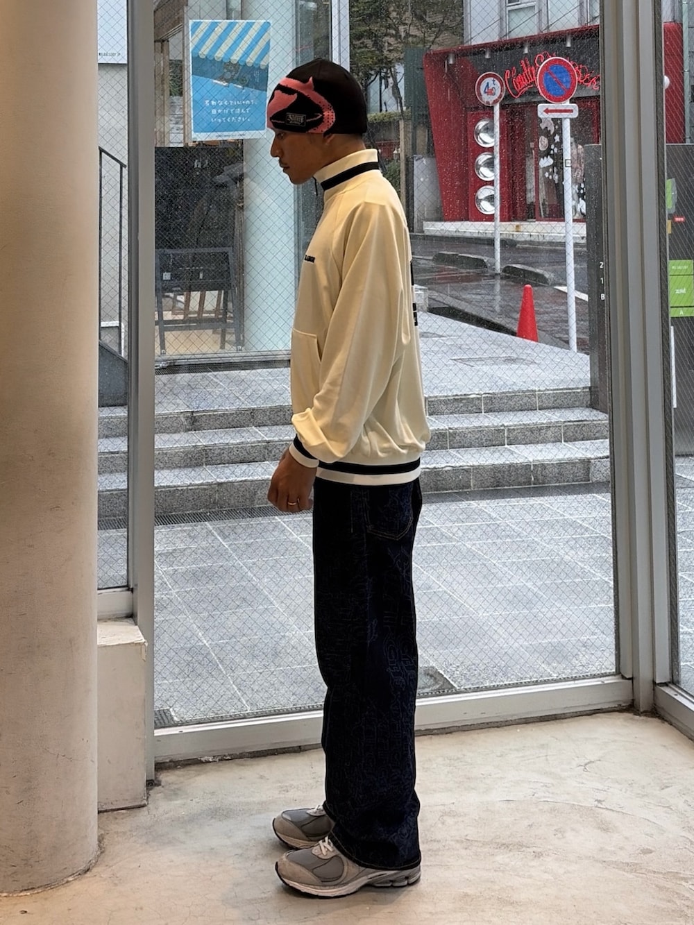 ホワイト系のブルゾン、ブルー系のデニムパンツ、ブルー系のキャップを着用したメンズの秋コーディネートの2枚目の写真