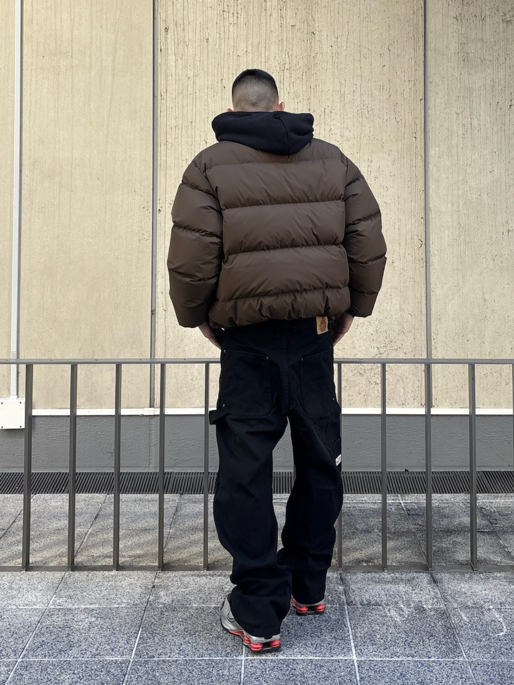 ブラック系のダウンジャケット/コート、ブラウン系のその他パンツを着用したメンズの冬コーディネートの4枚目の写真