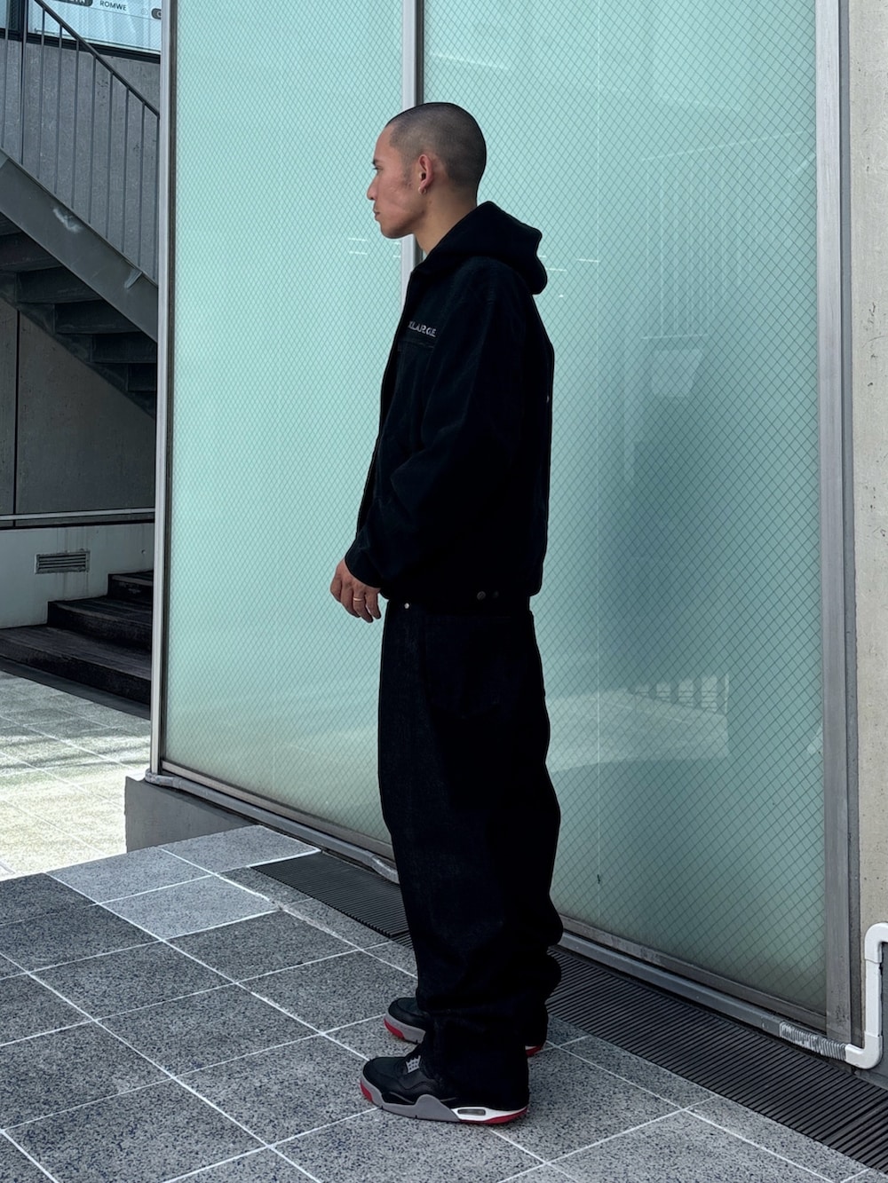 ブラック系のニット/セーター、ブラック系のデニムパンツ、ブラック系のその他アウターを着用したメンズの秋コーディネートの2枚目の写真