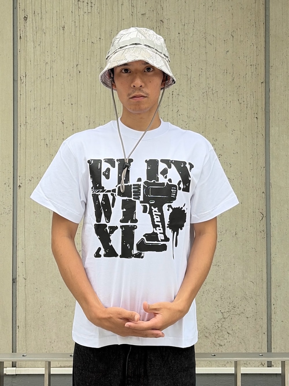 ホワイト系のTシャツ/カットソー、ブラック系のデニムパンツ、その他のハットを着用したメンズの夏コーディネートの6枚目の写真