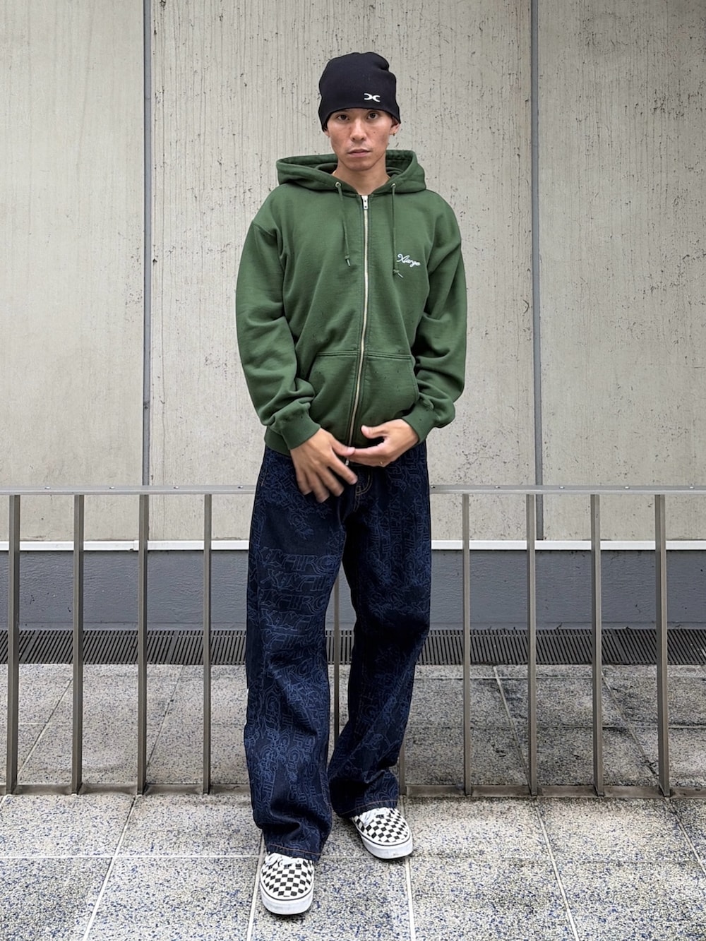 グリーン系のパーカー、ブルー系のデニムパンツ、レッド系のニットキャップ/ビーニーを着用したメンズの秋コーディネートの2枚目の写真