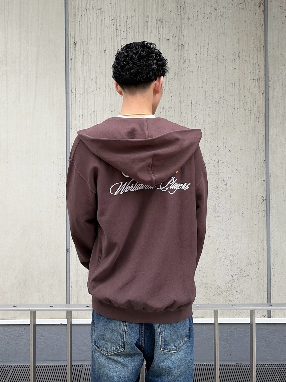 ベージュ系のTシャツ/カットソー、ブラウン系のパーカー、ブルー系のデニムパンツを着用したメンズの春コーディネートの8枚目の写真