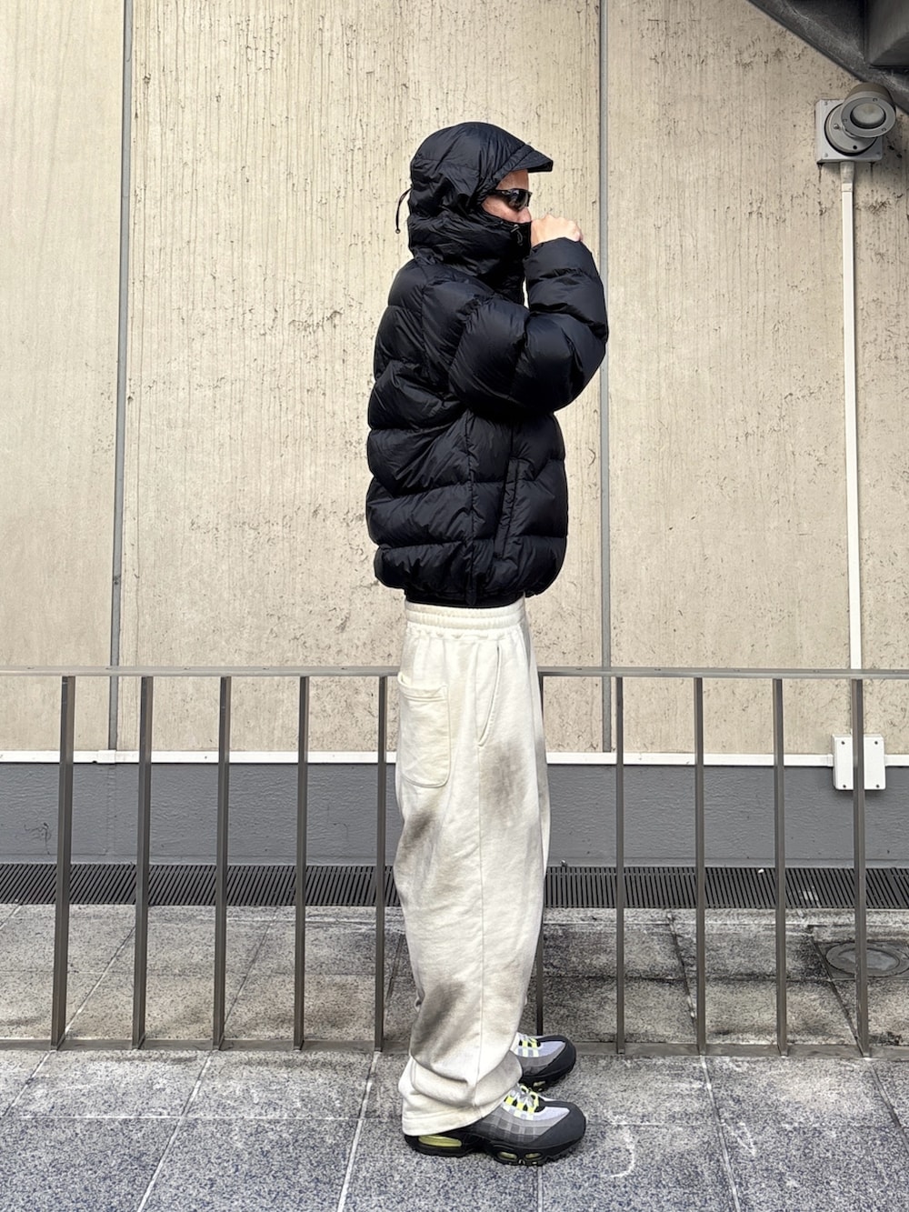 ブラウン系のダウンジャケット/コート、ホワイト系のスウェットパンツを着用したメンズの秋コーディネートの3枚目の写真