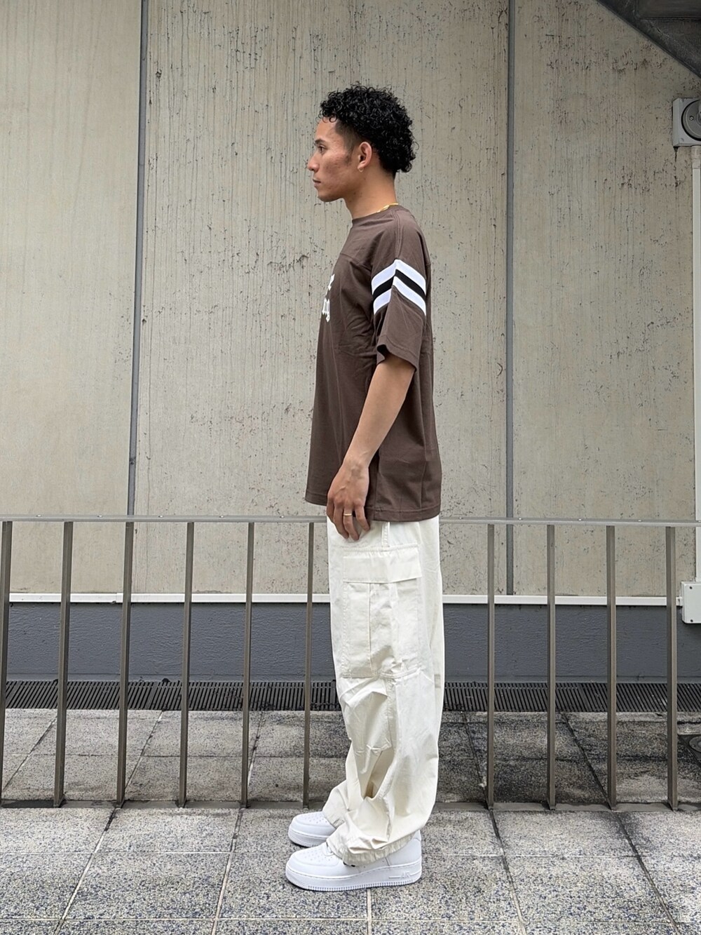 ブラウン系のTシャツ/カットソー、ホワイト系のカーゴパンツを着用したメンズの夏コーディネートの2枚目の写真