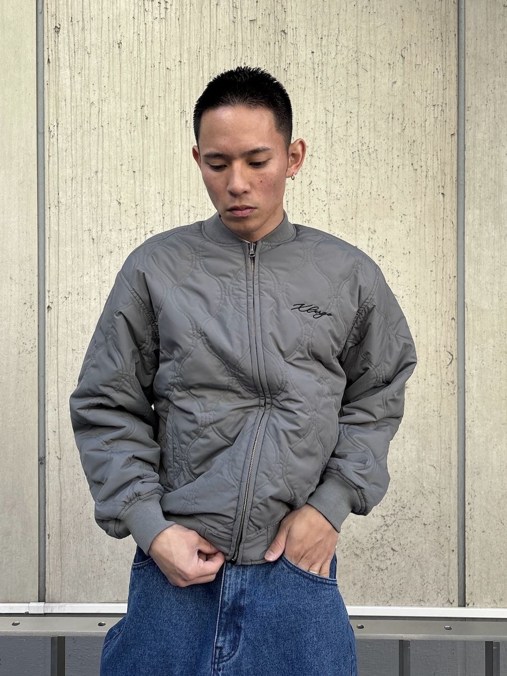 ブラック系のブルゾン、ブルー系のデニムパンツを着用したメンズの冬コーディネートの7枚目の写真