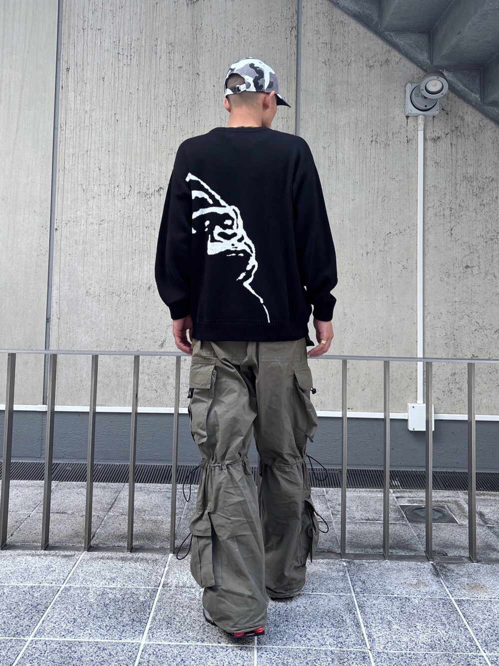 ブラック系のニット/セーター、グリーン系のカーゴパンツ、その他のキャップを着用したメンズの秋コーディネートの5枚目の写真
