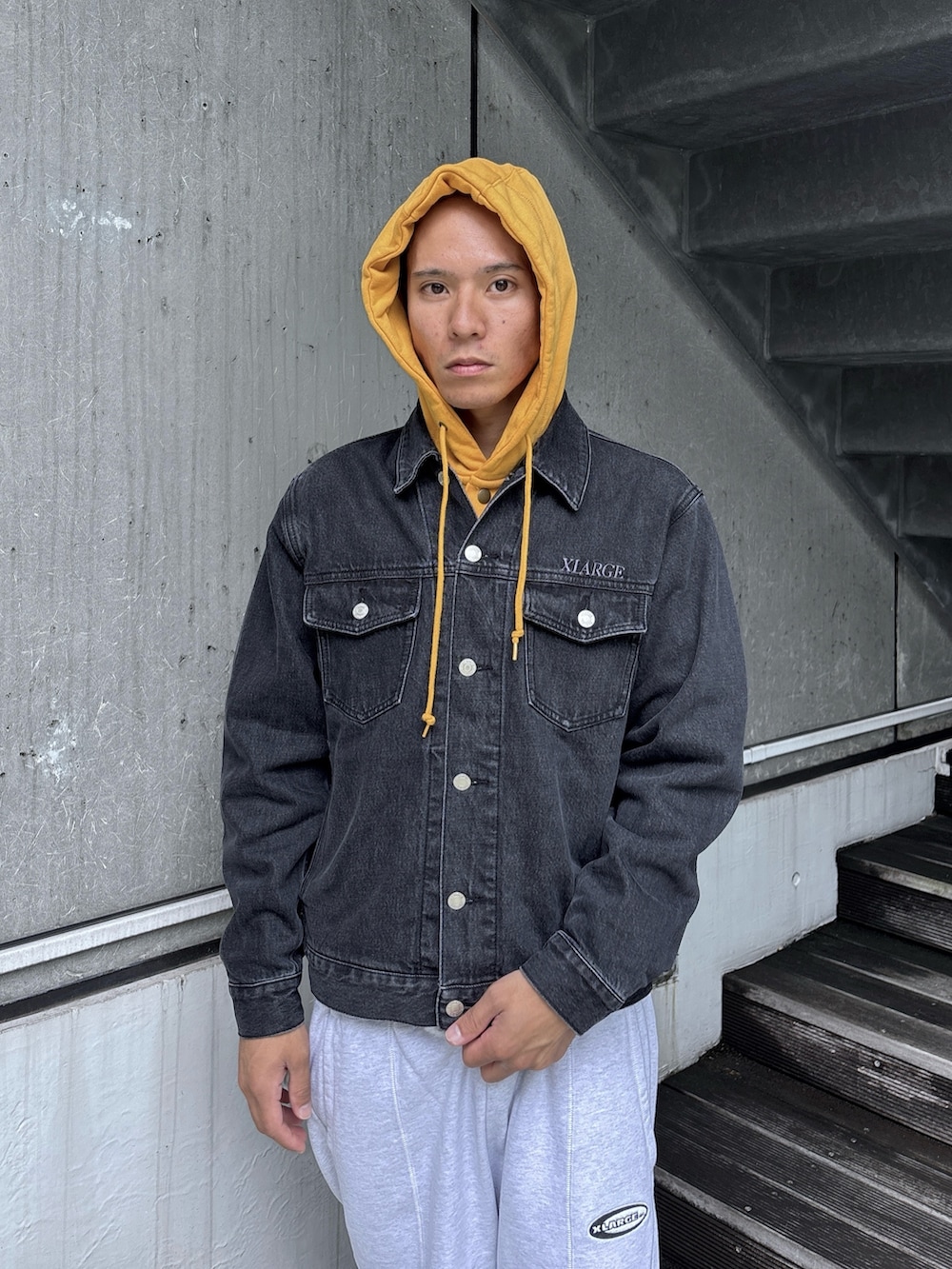 ブラック系のデニムジャケット、グレー系のスウェットパンツ、グレー系のパーカーを着用したメンズの秋コーディネートの6枚目の写真