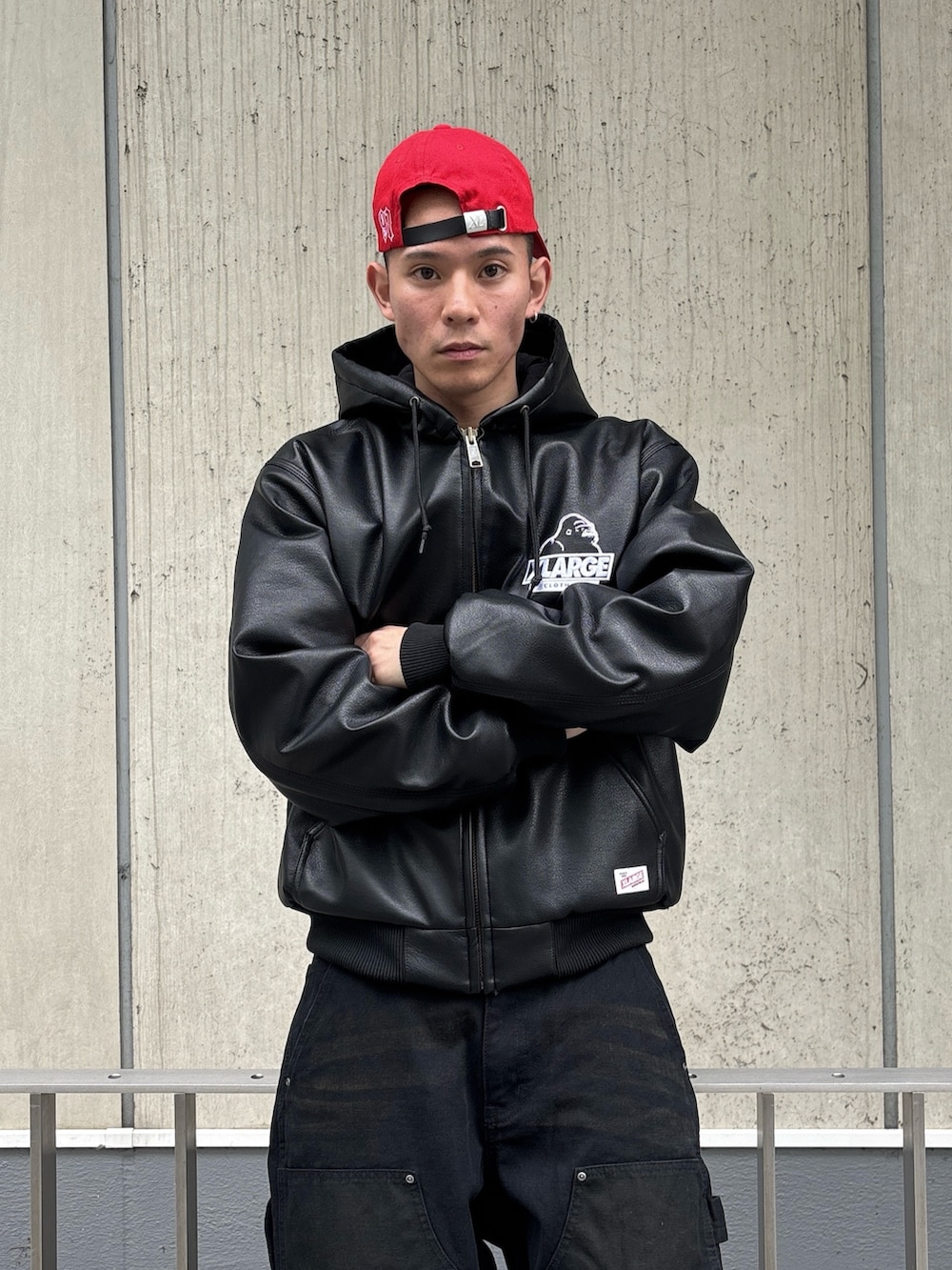 ブラック系のその他アウター、ブラウン系のその他パンツ、レッド系のキャップを着用したメンズの冬コーディネートの5枚目の写真