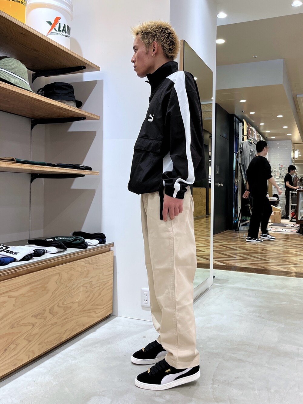 ブラック系のブルゾン、ベージュ系のその他パンツ、ブラック系のスニーカーを着用したメンズの秋コーディネートの2枚目の写真