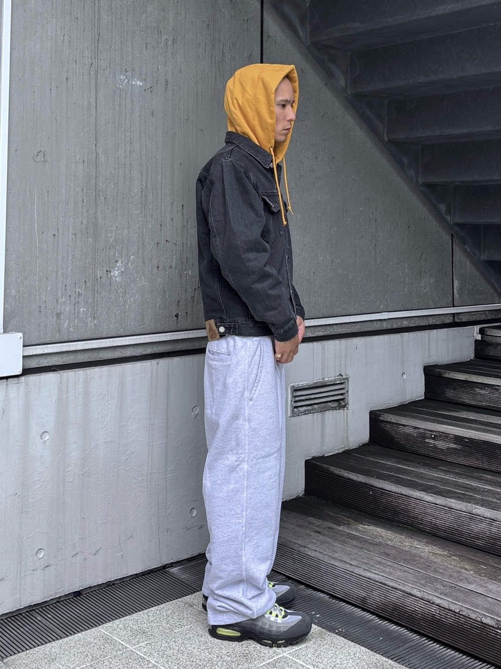 ブラック系のデニムジャケット、グレー系のスウェットパンツ、グレー系のパーカーを着用したメンズの秋コーディネートの4枚目の写真