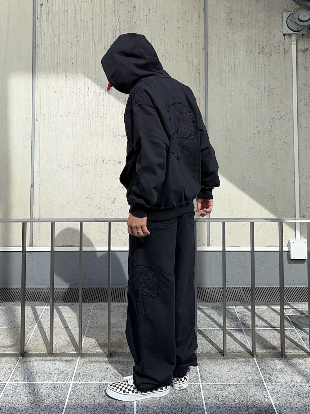 ブラック系のパーカー、ブラック系のその他パンツ、レッド系のキャップを着用したメンズの夏コーディネートの4枚目の写真