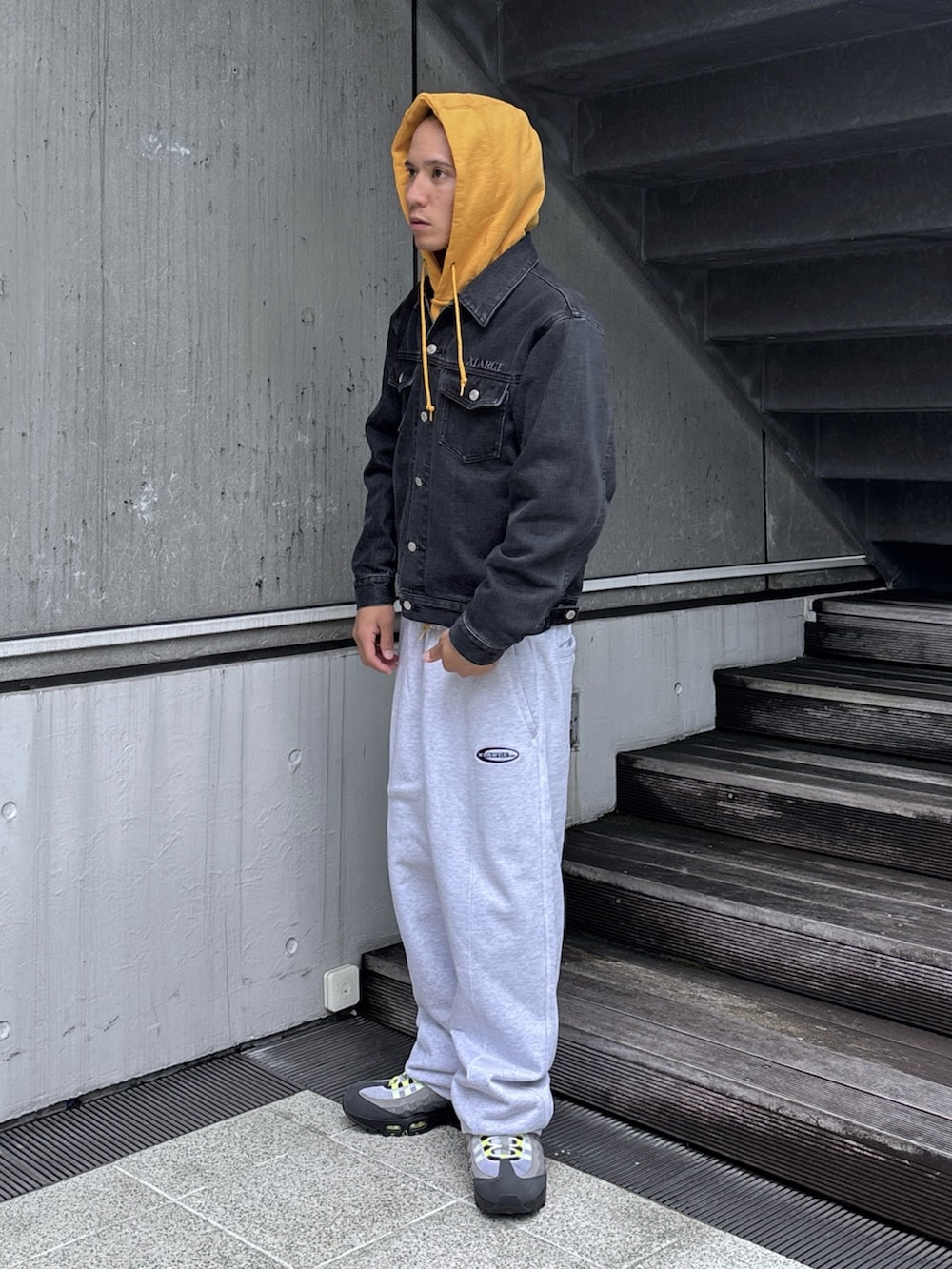 ブラック系のデニムジャケット、グレー系のスウェットパンツ、グレー系のパーカーを着用したメンズの秋コーディネートの2枚目の写真