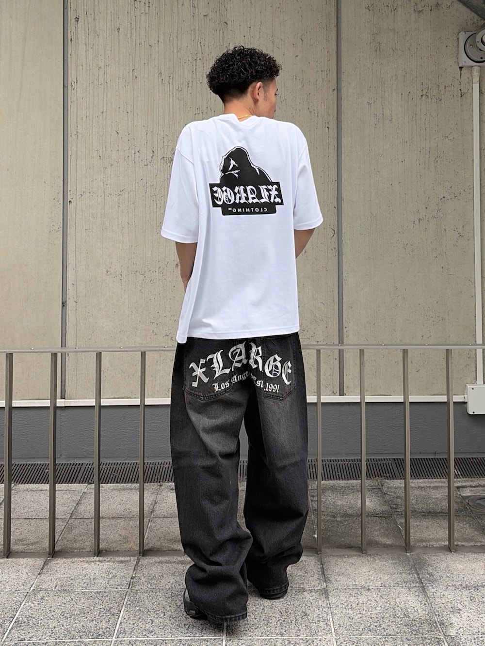 ホワイト系のTシャツ/カットソー、ブラック系のデニムパンツを着用したメンズの夏コーディネートの5枚目の写真