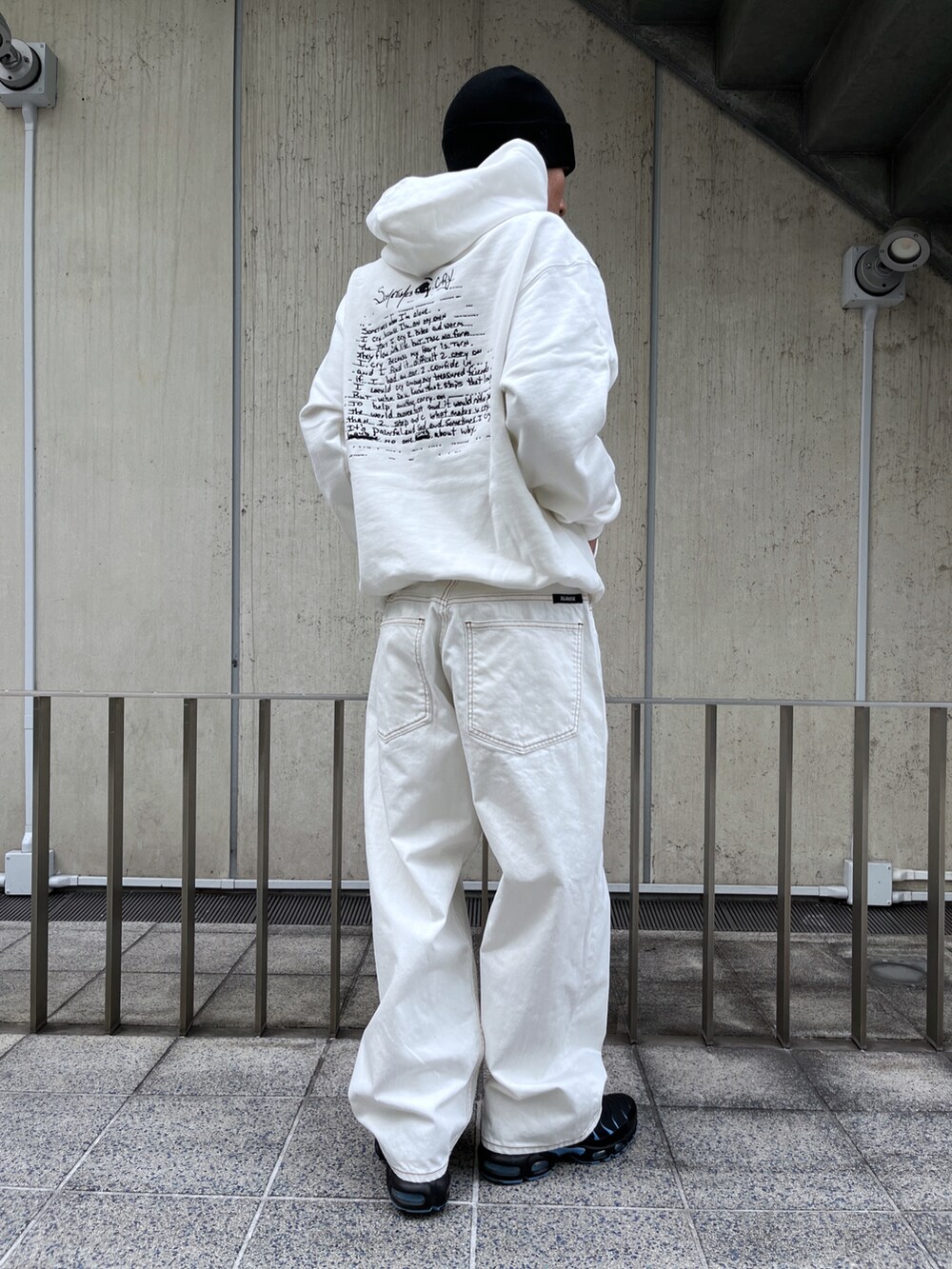ホワイト系のパーカー、ブルー系のデニムパンツ、ブラック系のニットキャップ/ビーニーを着用したメンズの冬コーディネートの3枚目の写真