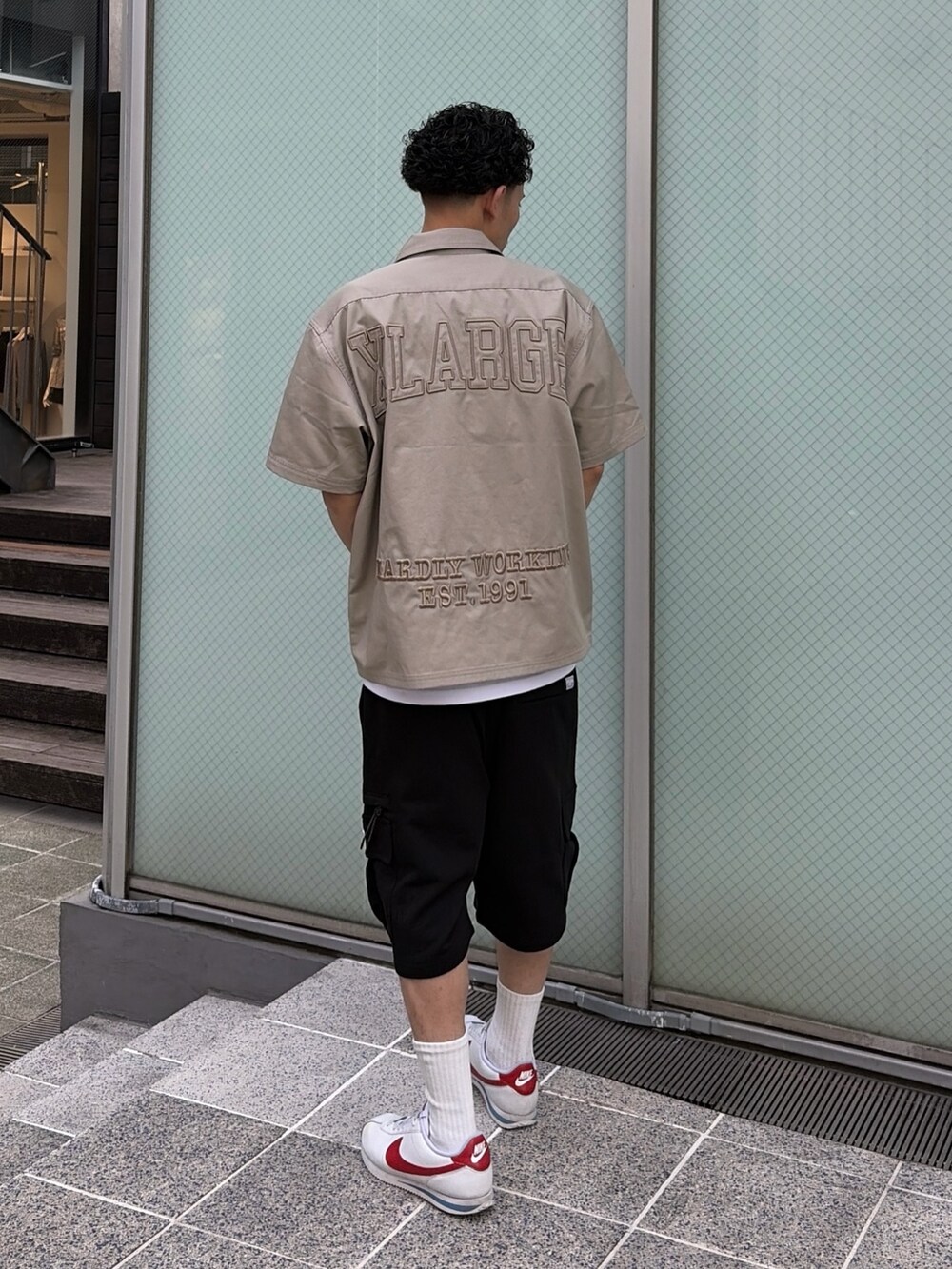 ブラック系のカーゴパンツ、グリーン系のシャツ/ブラウス、ホワイト系のTシャツ/カットソーを着用したメンズの春コーディネートの4枚目の写真