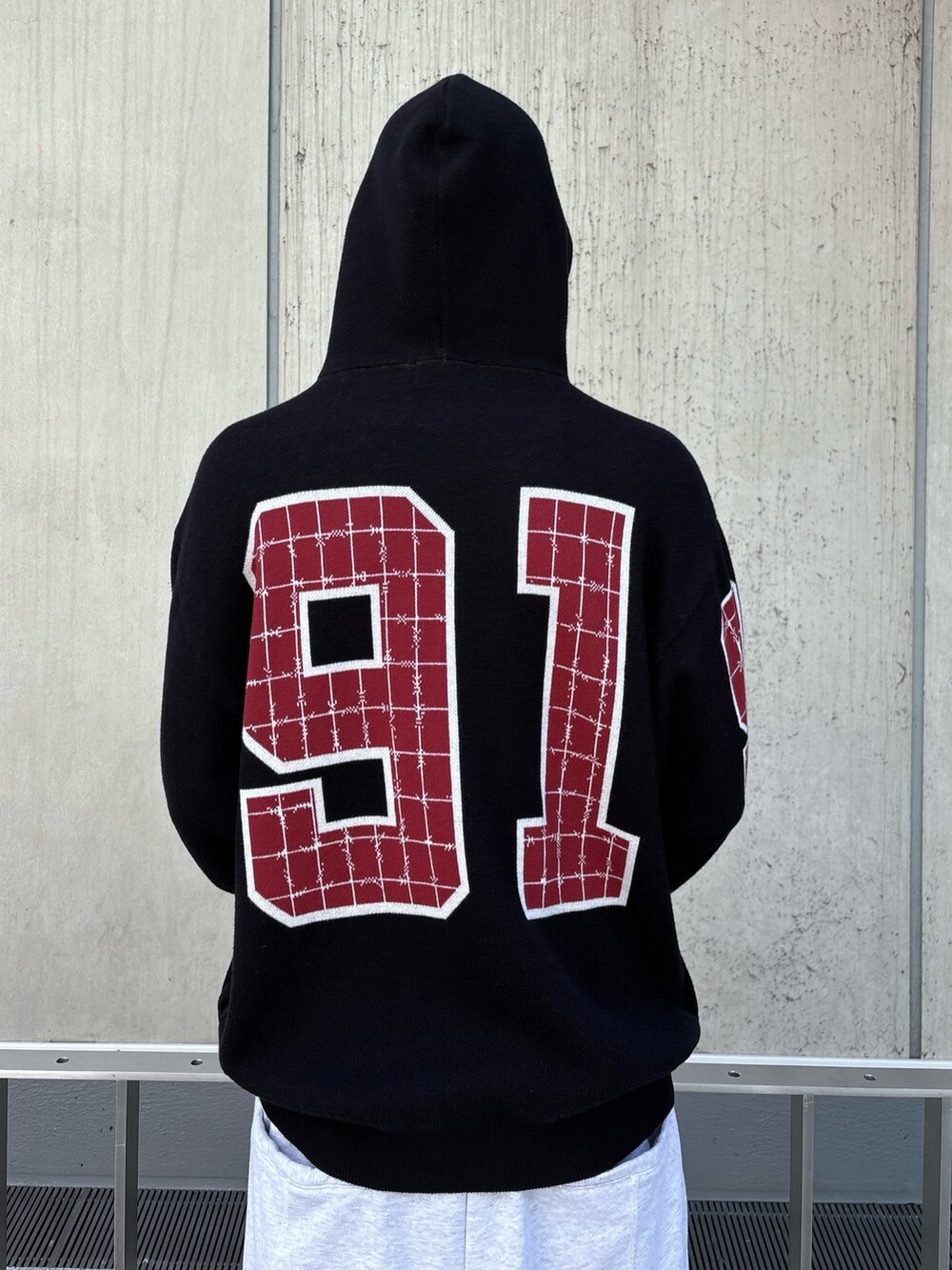 ブラック系のニット/セーター、グレー系のスウェットパンツを着用したメンズの秋コーディネートの6枚目の写真