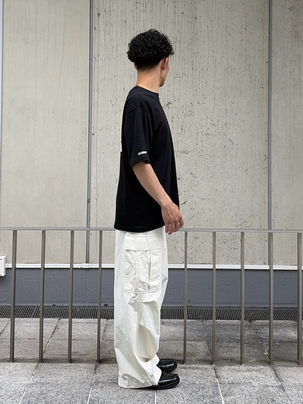 ブラック系のTシャツ/カットソー、ホワイト系のカーゴパンツを着用したメンズの夏コーディネートの3枚目の写真